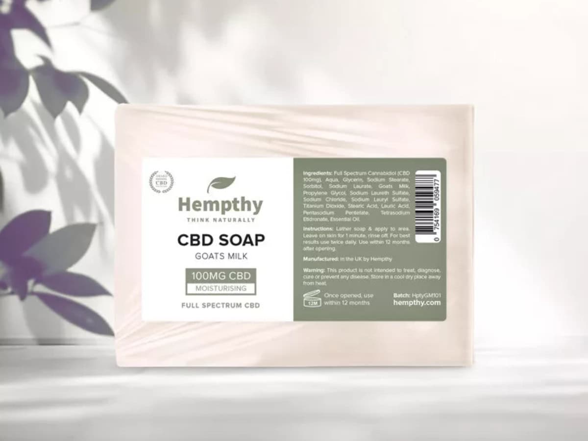 Hempthy CBD Soap sitting proudly in front of a white and purple flowery and shadowy background