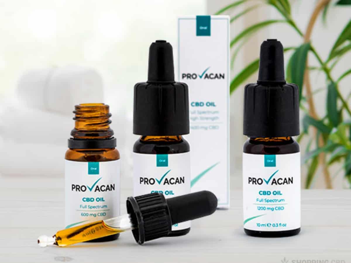 Provacan CBD Oils with filled pipette on table plant background