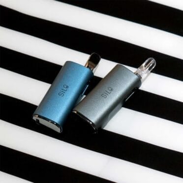 2x CCELL Silo Battery Black resting on striped background