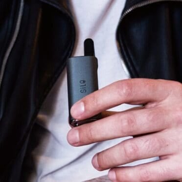 Person in white tee shirt with black jacket holding CCell Silo in hand