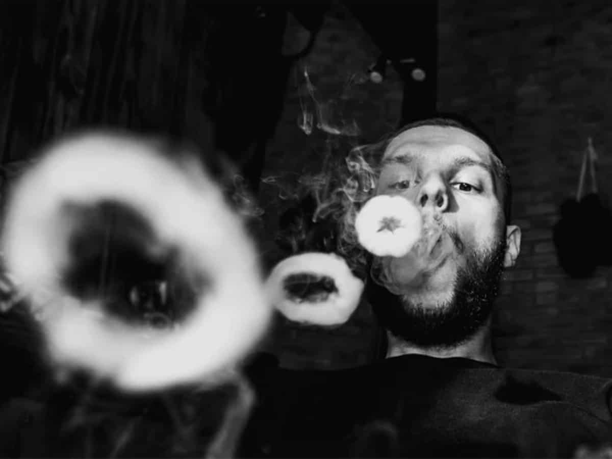 Man blowing vape cloud rings with the Goods CBD Vape Black background