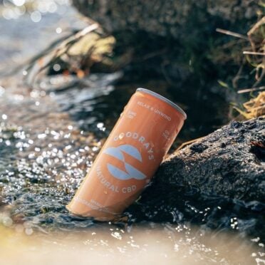Goodrays CBD Drinks Blood Orange in a stream by a rock