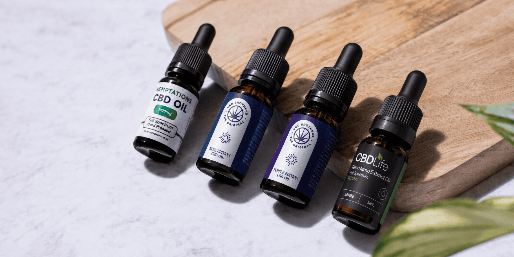 4x CBD oil bottles sitting on chopping board