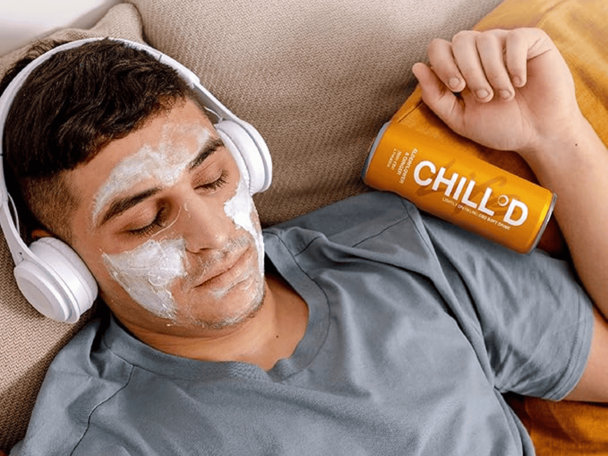CHILLD CBD Drinks man sleeping on sofa with face mask and headphones on