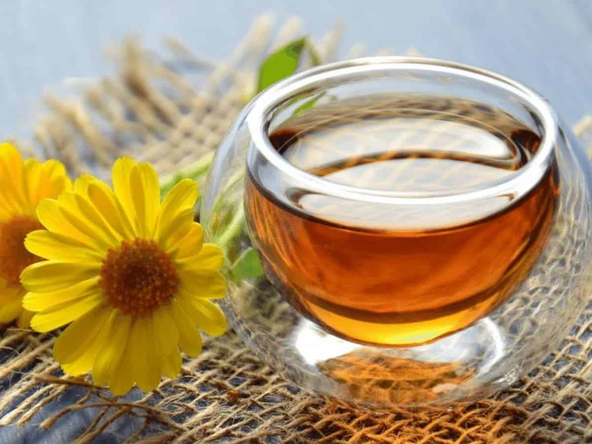 Lion's Mane Tea in a glass mug surrounded by flowers