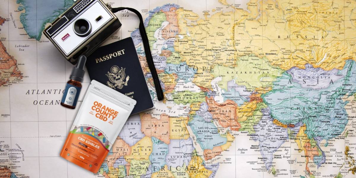 a camera, cbd gummies grab bag and bottle of cbd brothers blue edition cbd oil on a map of the world