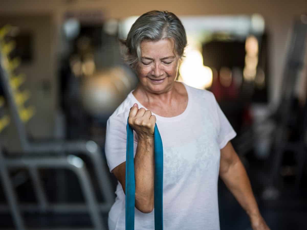 an older woman doing at-home exercises in a white t-shirt