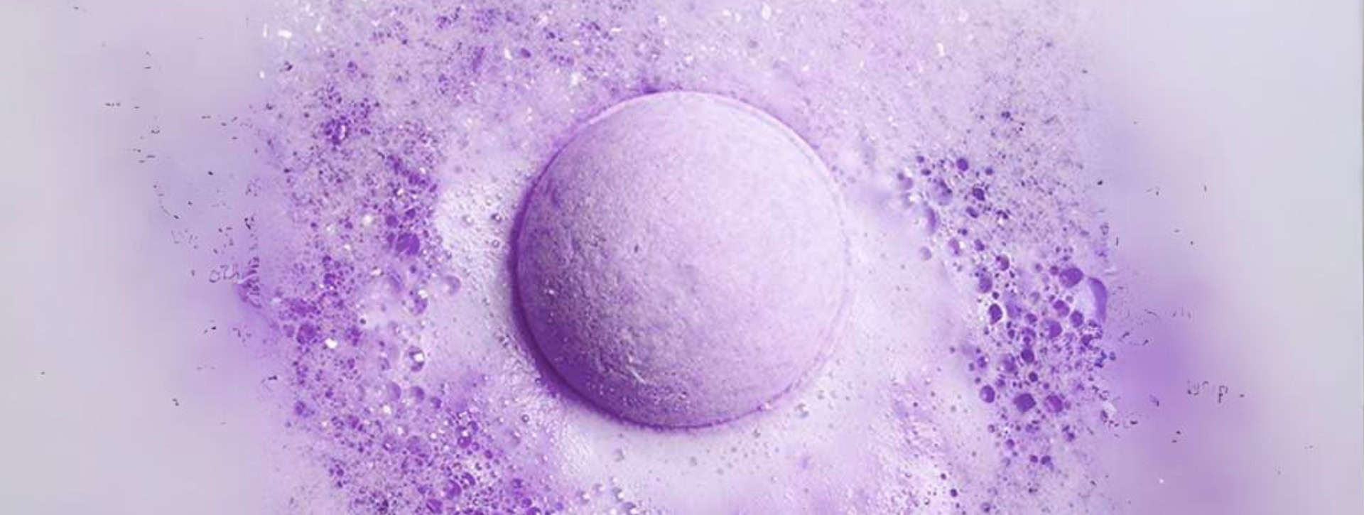 Vitality purple CBD bath bomb exploding in water