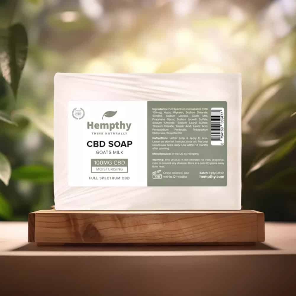Hempthy CBD Soap Goats Milk on wooden table with forest light breaking through trees background