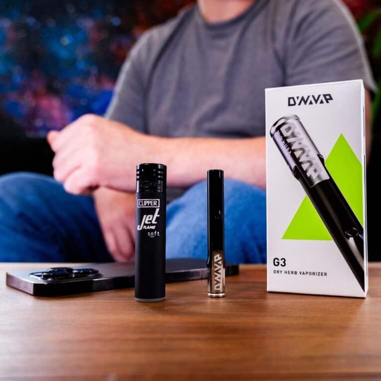 Dynavap G3 Packaging Device and Lighter on table with phone man in background