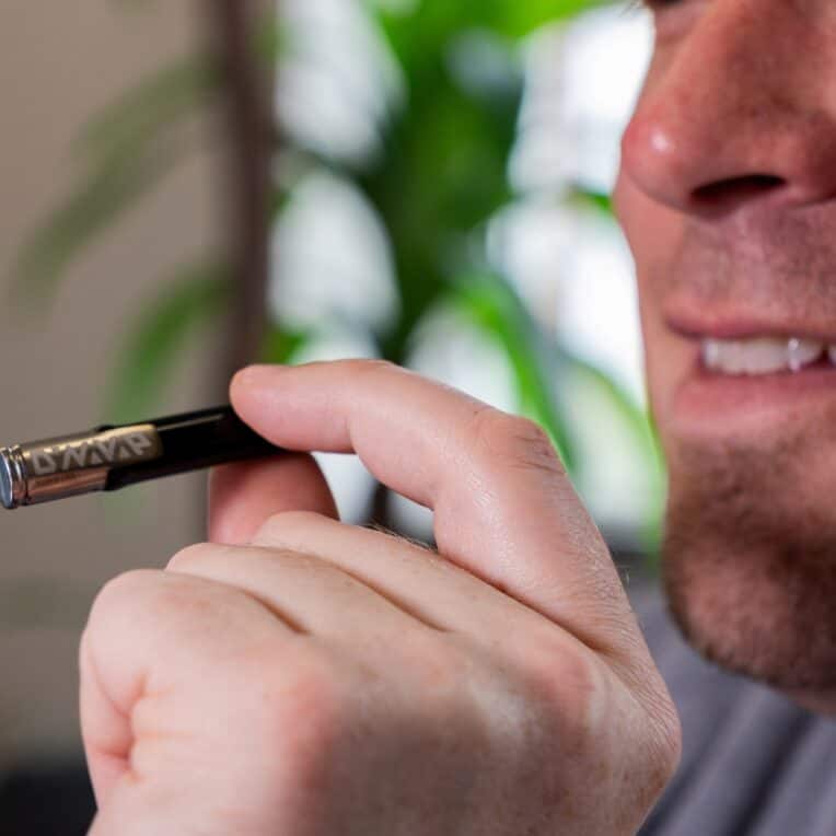 Man holding and inhaling from Dynavap G3 and smiling