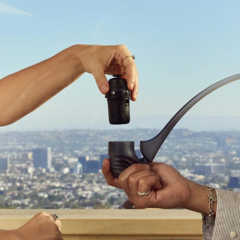 Puffco Proxy 2025 two hands holding the chamber over the device in front of a skyscraper City background