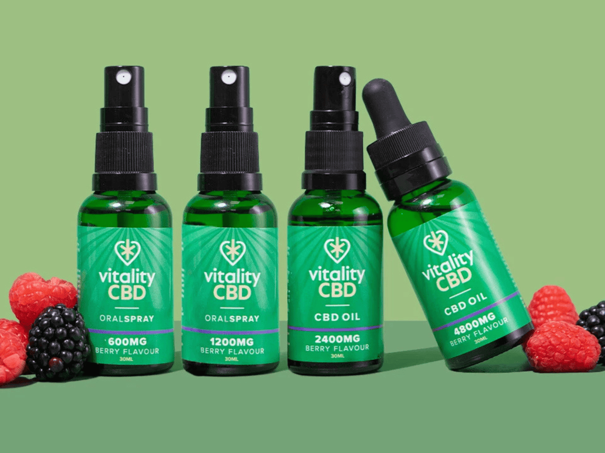 Vitality CBD Oils side by side green background with berries on either side of the 4 oils